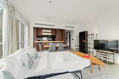 a living room with a white couch and a television at FIRST CLASS 1BR Downtown Luxury in Dubai