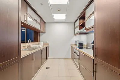 a large kitchen with wooden cabinets and stainless steel appliances at FIRST CLASS 1BR Downtown Luxury in Dubai
