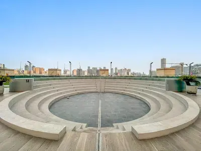 a large amphitheater with a city in the background at FIRST CLASS 1BR Relaxing Vibes in JVC in Dubai