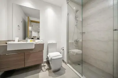 a bathroom with a toilet and a sink and a shower at FIRST CLASS 1BR Relaxing Vibes in JVC in Dubai