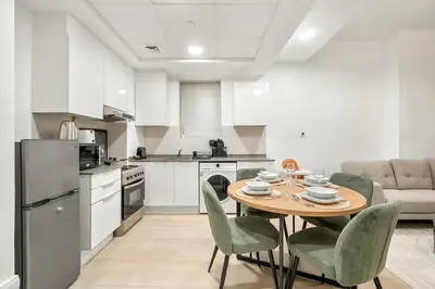 a kitchen and dining room with a table and chairs at FIRST CLASS 1BR Relaxing Vibes in JVC in Dubai