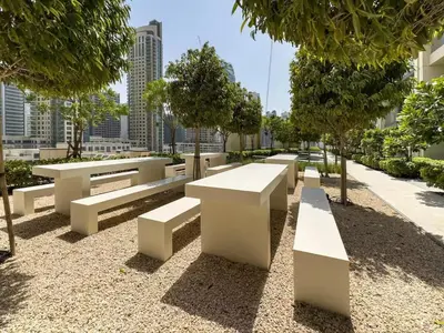 a row of white benches in a park at Stunning 2BR- Burj Royale 411 - Burj Khalifa View in Dubai