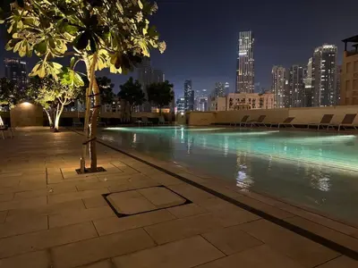 a swimming pool with a city skyline at night at Stunning 2BR- Burj Royale 411 - Burj Khalifa View in Dubai