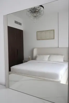 a bedroom with a large white bed and a chandelier at Madinat Jumeirah Living in Dubai