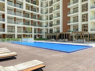 a large apartment building with a large swimming pool at FIRST CLASS Studio Chic and Comfy in Jewelz in Dubai