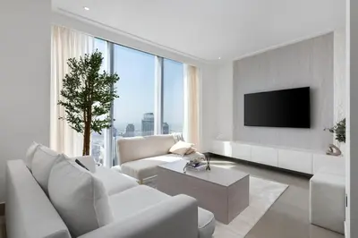 a living room with white furniture and a large window at Maison Privee - City Heights Retreat with Panoramic Skyline Views in Dubai