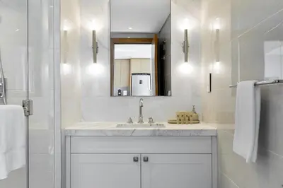 a white bathroom with a sink and a mirror at Maison Privee - City Heights Retreat with Panoramic Skyline Views in Dubai