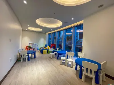 a waiting room with blue tables and white chairs at Maison Privee - City Heights Retreat with Panoramic Skyline Views in Dubai