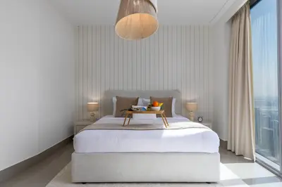 a bedroom with a bed with a table on it at Maison Privee - City Heights Retreat with Panoramic Skyline Views in Dubai
