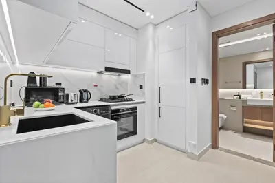 a white kitchen with a sink and a stove at FIRST CLASS 1BR Elegant Living with City Views in Dubai