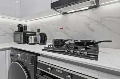 a kitchen with a stove with pots and pans on it at FIRST CLASS 1BR Elegant Living with City Views in Dubai
