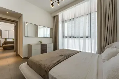 a bedroom with a bed and a large window at Modern 1BR with Terrace, Rooftop Pool and PS5 in JVC in Dubai