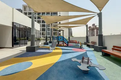 a building with a playground with benches and a play area at Airstay - Modern 1BR - Pool Views - Azizi 61 - Monthly Offer Available in Dubai