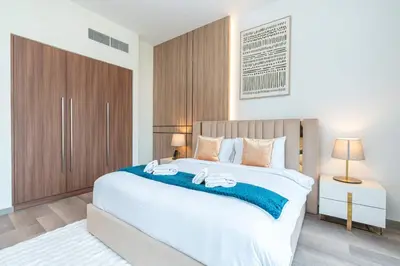 a bedroom with a large bed with two towels on it at PVH - 1BR with Burj Khalifa View - Imperial Avenue in Dubai