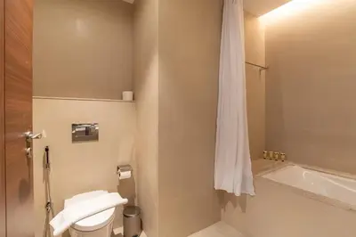 a bathroom with a toilet and a bath tub at PVH - 1BR with Burj Khalifa View - Imperial Avenue in Dubai