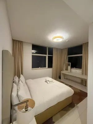 a bedroom with a large white bed and windows at Wecation- Chic 2BR Damac Maison Cour Jardin Business Bay in Dubai