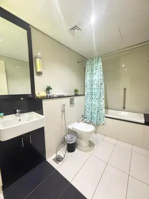 a bathroom with a sink and a toilet and a mirror at Wecation- Chic 2BR Damac Maison Cour Jardin Business Bay in Dubai