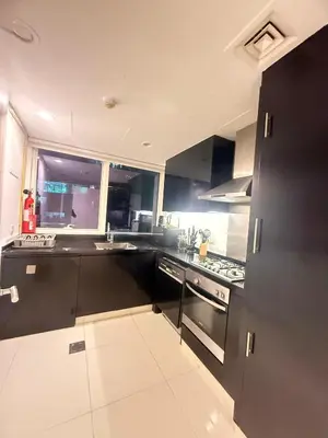 a kitchen with black and white cabinets and appliances at Wecation- Chic 2BR Damac Maison Cour Jardin Business Bay in Dubai