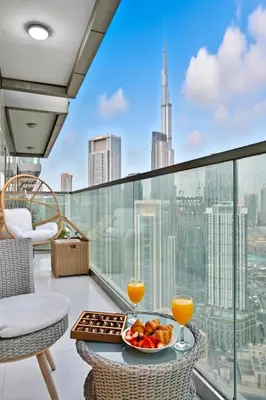 a balcony with a table and two glasses of orange juice at Luxury 2B Burj Khalifa NYE Views, 5-Star Amenities in Dubai
