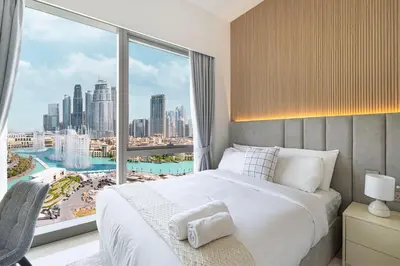 a bedroom with a bed and a large window at Full Burj Khalifa And Fountains View Exclusive 2BR Luxury Apartment In The Heart Of Downtown Dubai in Dubai