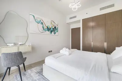 a bedroom with a white bed and a chair at Full Burj Khalifa And Fountains View Exclusive 2BR Luxury Apartment In The Heart Of Downtown Dubai in Dubai