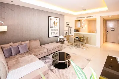 a living room with a couch and a dining room at Luxury Fully Furnished 1BHK With Burj Khalifa View at paramount Towers in Dubai