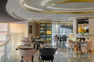a restaurant with tables and chairs and a ceiling at Luxury Fully Furnished 1BHK With Burj Khalifa View at paramount Towers in Dubai