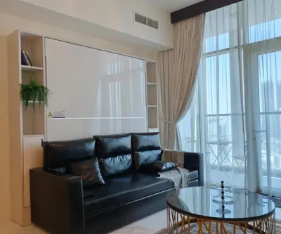 a living room with a black leather couch and a glass table at Burj View 1BHK near Down Town - Panoramic Balcony View -Pool and Gym in Dubai