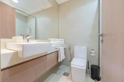 a bathroom with a sink and a toilet and a mirror at Meydan - Modern Family - 2BR Apartment - Azizi Riviera in Dubai