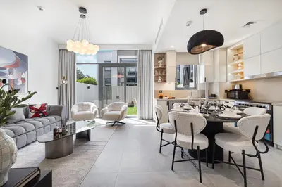 a kitchen and living room with a table and chairs at Upscale 4BR Villa, Bali Pool, Resort Escape in Dubai
