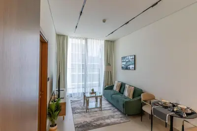 a living room with a green couch and a table at 1BR in Trillionaire Residences by Binghatti with canal view in Dubai