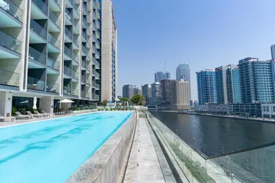 a swimming pool in the middle of a city with buildings at 1BR in Trillionaire Residences by Binghatti with canal view in Dubai