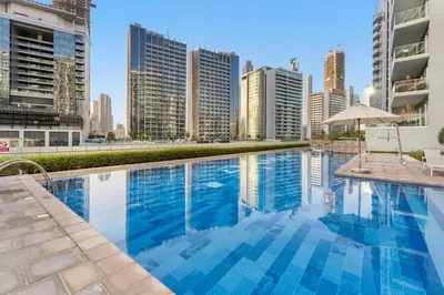 a swimming pool in a city with tall buildings at Waves - Modern City Escape 1BR Apt With Balcony in Dubai
