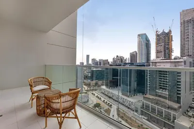 a balcony with a chair and a view of a city at Waves - Modern City Escape 1BR Apt With Balcony in Dubai