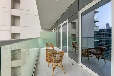 a balcony with chairs and a table on a building at Waves - Modern City Escape 1BR Apt With Balcony in Dubai