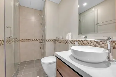 a bathroom with a sink and a toilet and a shower at Waves - Modern City Escape 1BR Apt With Balcony in Dubai