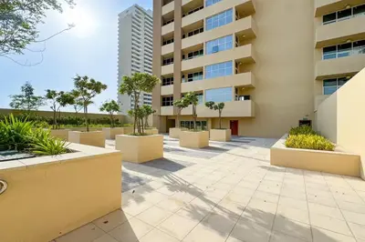 a courtyard of a building with trees and plants at High-Floor Studio Ghalia JVC with an Amazing View in Dubai