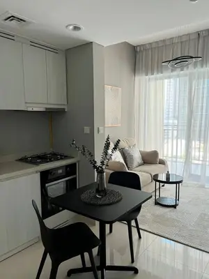 a kitchen and living room with a table and a couch at Stylish 1BR in Zada Tower near Business Bay Metro in Dubai