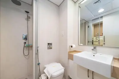 a bathroom with a sink and a toilet and a mirror at Luxury Upgraded Palm Studio with Marina and Yacht Views in Dubai