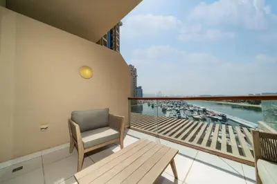 a balcony with a chair and a view of a harbor at Luxury Upgraded Palm Studio with Marina and Yacht Views in Dubai
