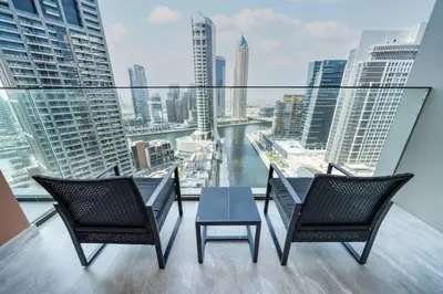 two chairs and a table on a balcony with a view at Modern Studio in Peninsula One with Canal Views in Dubai