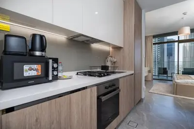 a kitchen with a microwave and a stove top oven at Modern Studio in Peninsula One with Canal Views in Dubai