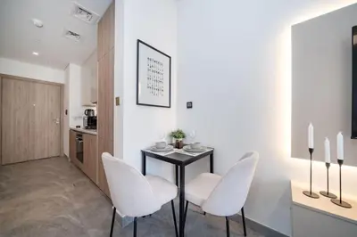 a dining room with a black table and white chairs at Luxury Studio in Peninsula One, Bay Views in Dubai
