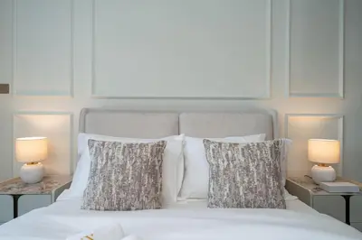 a bedroom with a white bed with pillows and two lamps at Luxury Studio in Peninsula One, Bay Views in Dubai