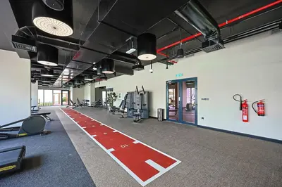 a gym with a red carpet in a room at Chic Living in Meraki comfy studio in Dubai