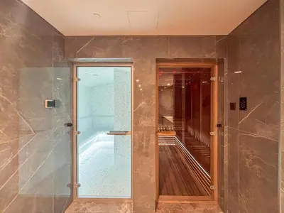 a bathroom with a walk in shower and a glass door at Frank Porter - Peninsula Five, Business Bay in Dubai