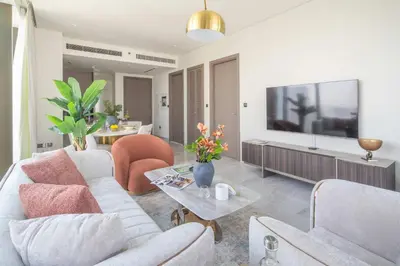 a living room with a white couch and a tv at Frank Porter - Peninsula Five, Business Bay in Dubai