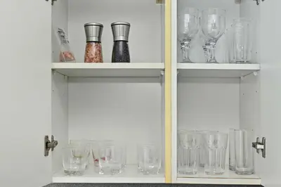 a cabinet filled with empty glasses on display at Spacious modern 2 Bed and Maids I Sleeps 7 in Dubai