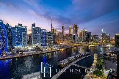 a city at night with a river and buildings at LUX The 15 Northside Burj Khalifa View Suite in Dubai