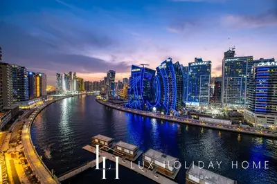 a city at night with a river and buildings at LUX The 15 Northside Burj Khalifa View Suite in Dubai